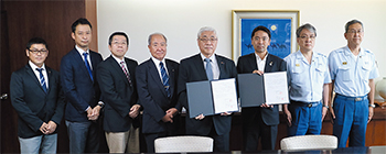 協定書を手にする篠崎院長（右から4人目）と松尾市長（その右）